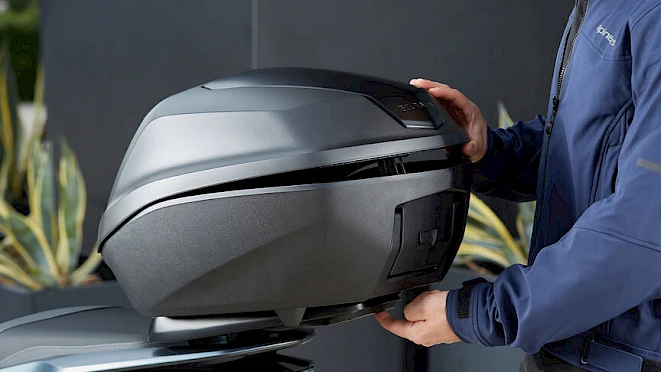 Black Honda genuine top case being fitted on a motorcycle – genuine accessories with two-year warranty