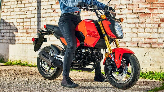 Red Honda MSX125 Grom at a brick wall with rider – agile A1 motorcycle for the city