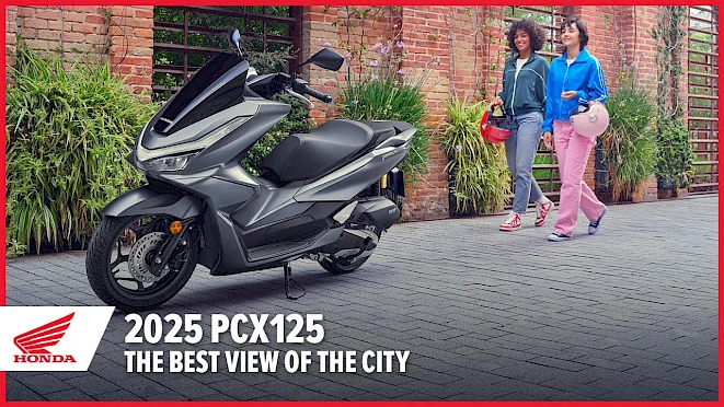 Grey Honda PCX125 in front of a green brick wall, two women with helmets – A1 scooter for commuters