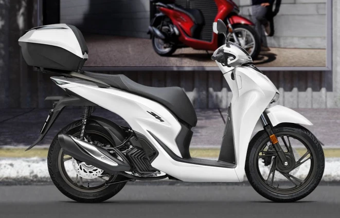 Moto dès 16 ans : Honda SH125 blanc avec top case, vu de profil sur la route