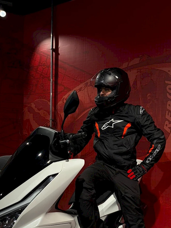 Aluguer de equipamento de mota em Zurique – condutor com conjunto completo Alpinestars e capacete numa scooter de aluguer